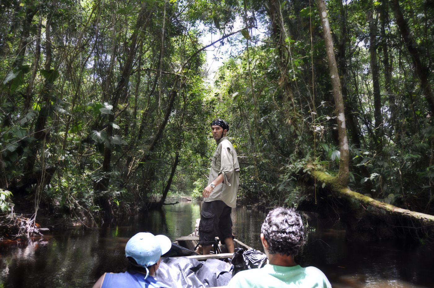 Shane Reynolds standing in a boat on a river deep in the Guyana jungle