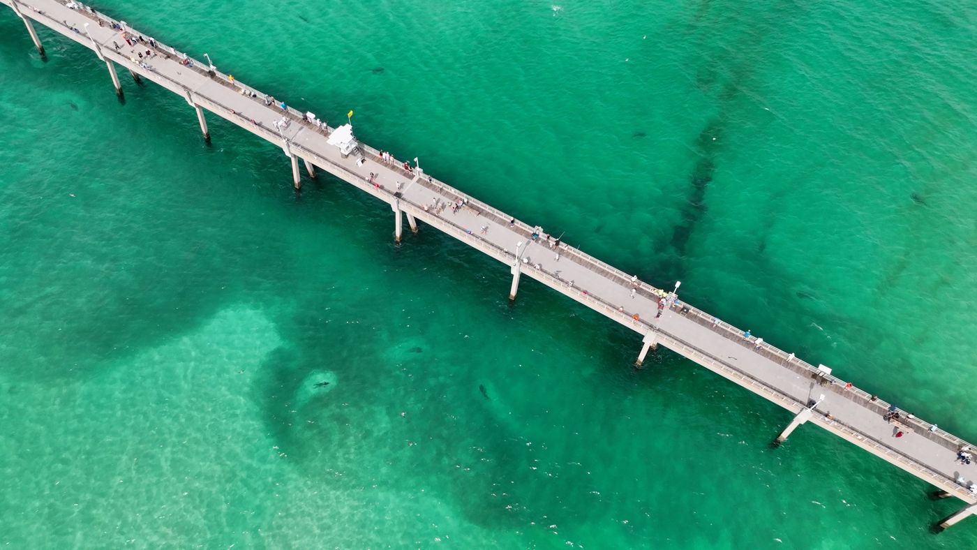 Aerial view of the Okaloosa Island Pier over green water