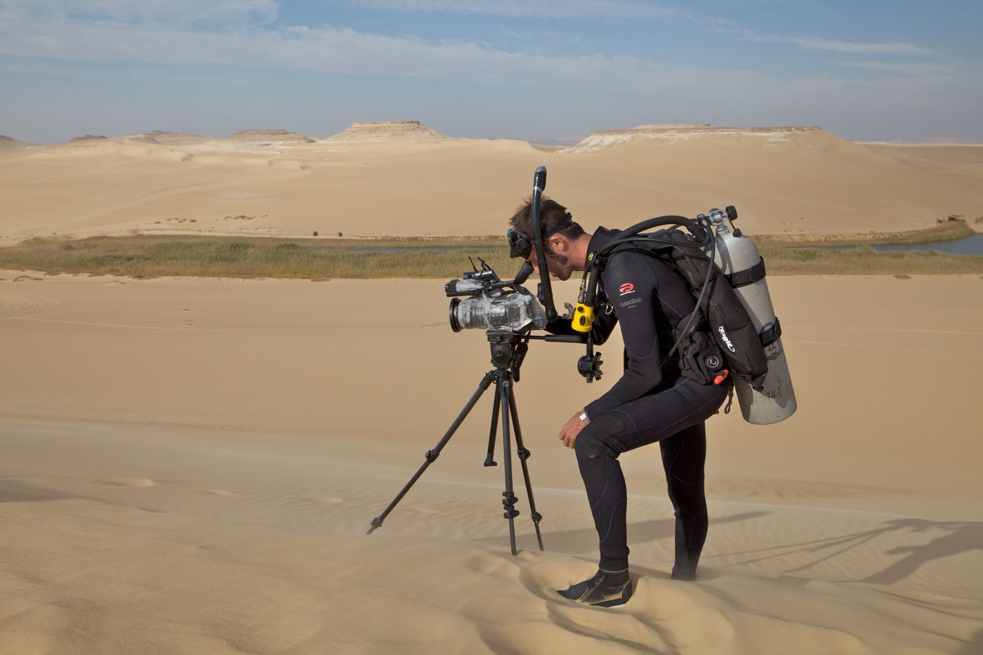 Shane Reynolds in dive gear filming on a tripod in the Sahara desert