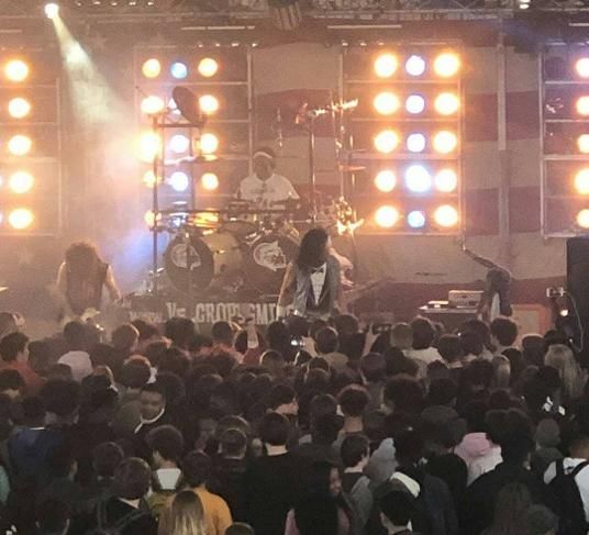 A packed crowd in front of a lit stage