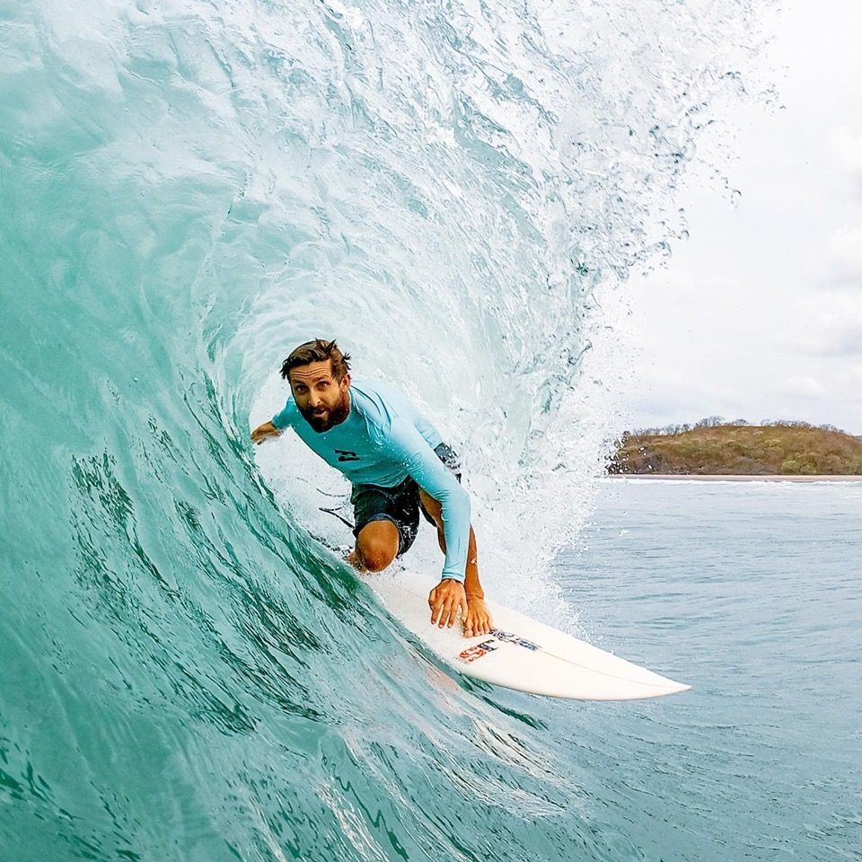 Dylan Sims crouched inside a barreling wave